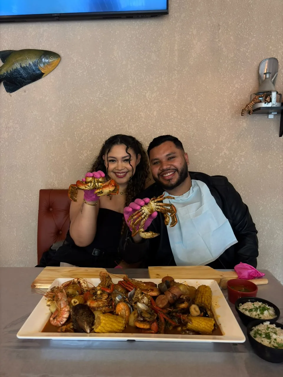 Casal com luvas segurando caranguejos
